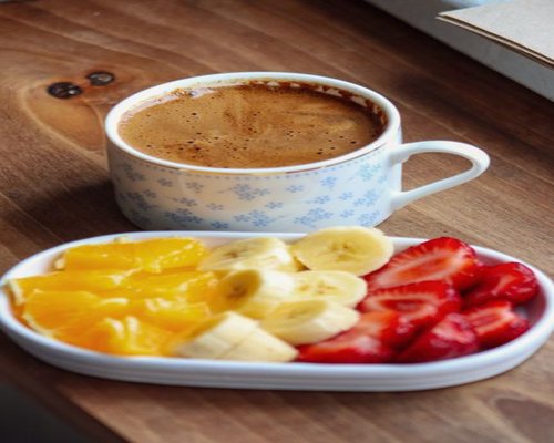 A quiet relaxing afternoon with a cup of coffee and fresh fruit on a wooden table